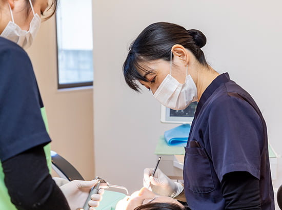 治療を行う女性歯科医師の写真